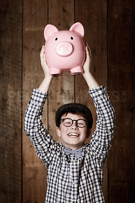 Buy stock photo Young child, piggy bank and happy in portrait in studio, money saving and cash savings in youth with retro fashion. Boy, smile and face for coin banking and safe for bills with glasses by backdrop