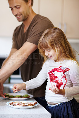 Buy stock photo A little girl making breakfast with her father