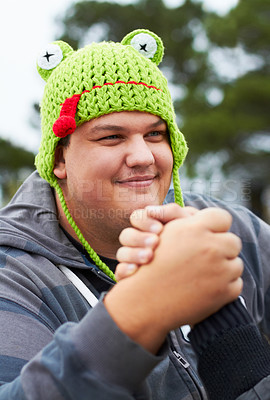 Buy stock photo A young man wearing a frog-shaped cap busy arm wrestling outside
