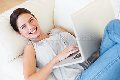 Buy stock photo Portrait, happy woman and relax with laptop on sofa with social media and reading in her home. Lying down, smile and face of female online in living room with subscription service and entertainment