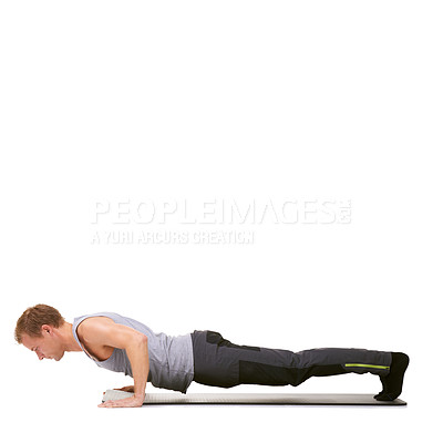 Buy stock photo A fit young man doing push-ups on his exercise mat while isolated on white