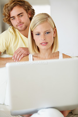 Buy stock photo Serious, laptop and young couple on sofa browsing on social media or the internet at apartment. Relax, technology and man and woman doing research on website with computer in living room at home.