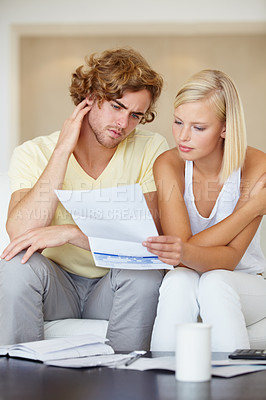 Buy stock photo Couple, stress for bills and reading documents on sofa with debt, financial planning or budget risk and worry at home. Confused man and woman with house loan invoice, bankruptcy or mortgage paperwork