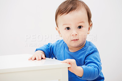 Buy stock photo Baby, portrait and balance for walking steps in home for childhood development, safety or mockup space. Boy, kid and face or holding furniture for growing support or progress, learning or curious