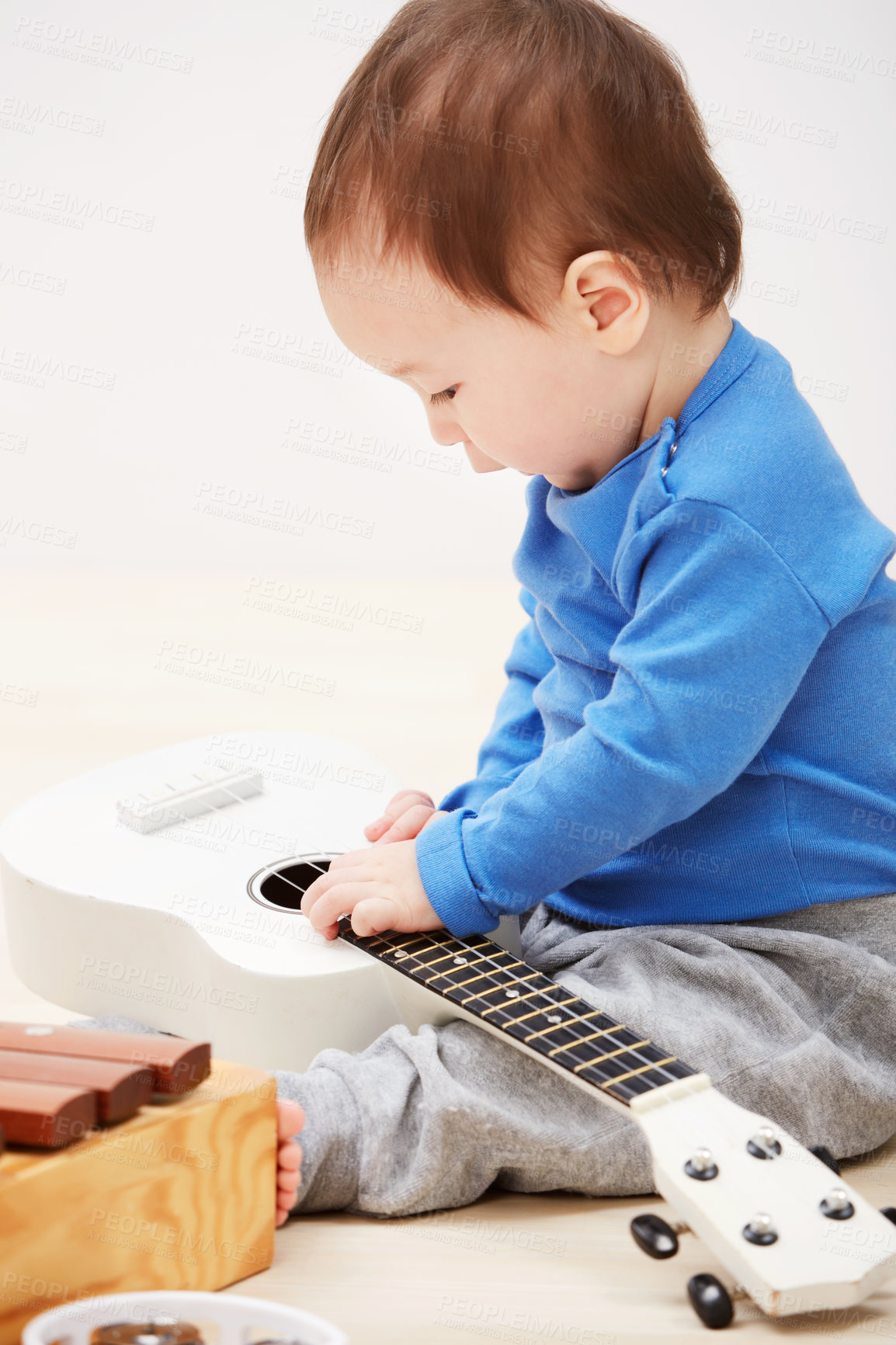 Buy stock photo Baby, guitar toys and play in home for entertainment joy, childhood development or education. Boy, kid and instruments for musical strings for song learning in apartment or growing, progress or games