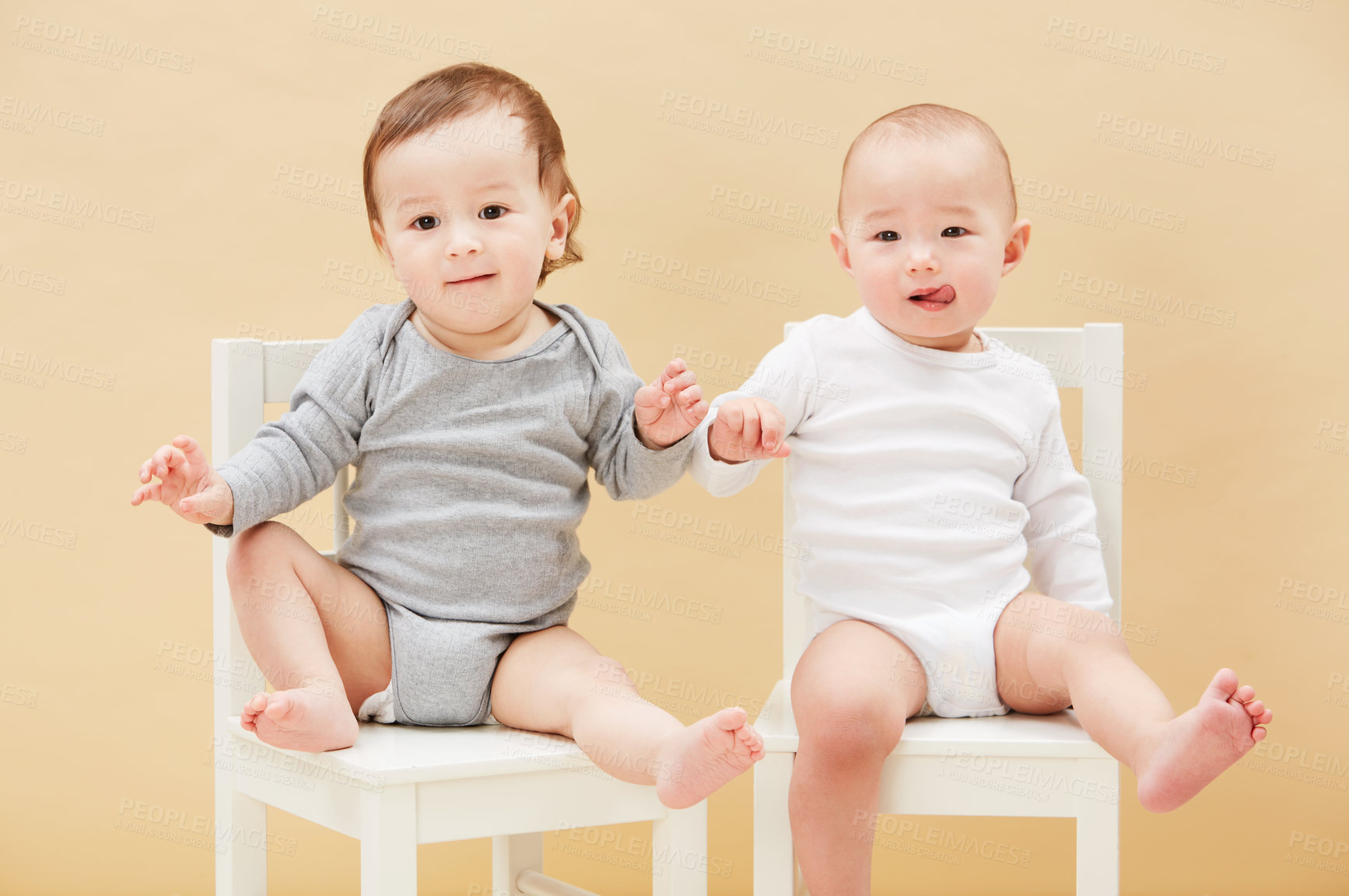 Buy stock photo Portrait, chair and baby boys for growth or child development in studio on an orange background. Children, cute or adorable and sibling or small infant kids sitting together for family bonding