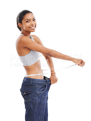 Buy stock photo A young woman in an oversized pair of pants measuring her waist