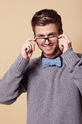 Buy stock photo Portrait, smile and glasses for fashion with a man in studio on a tan background for vision or style. Style, eyewear and a confident young geek or nerd with prescription frame lenses for eyesight