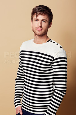 Buy stock photo Fashion, style and portrait of man in studio in trendy, stylish and casual clothes on beige background. Serious, attractive and person with confidence in jersey for positive attitude, pride and cool