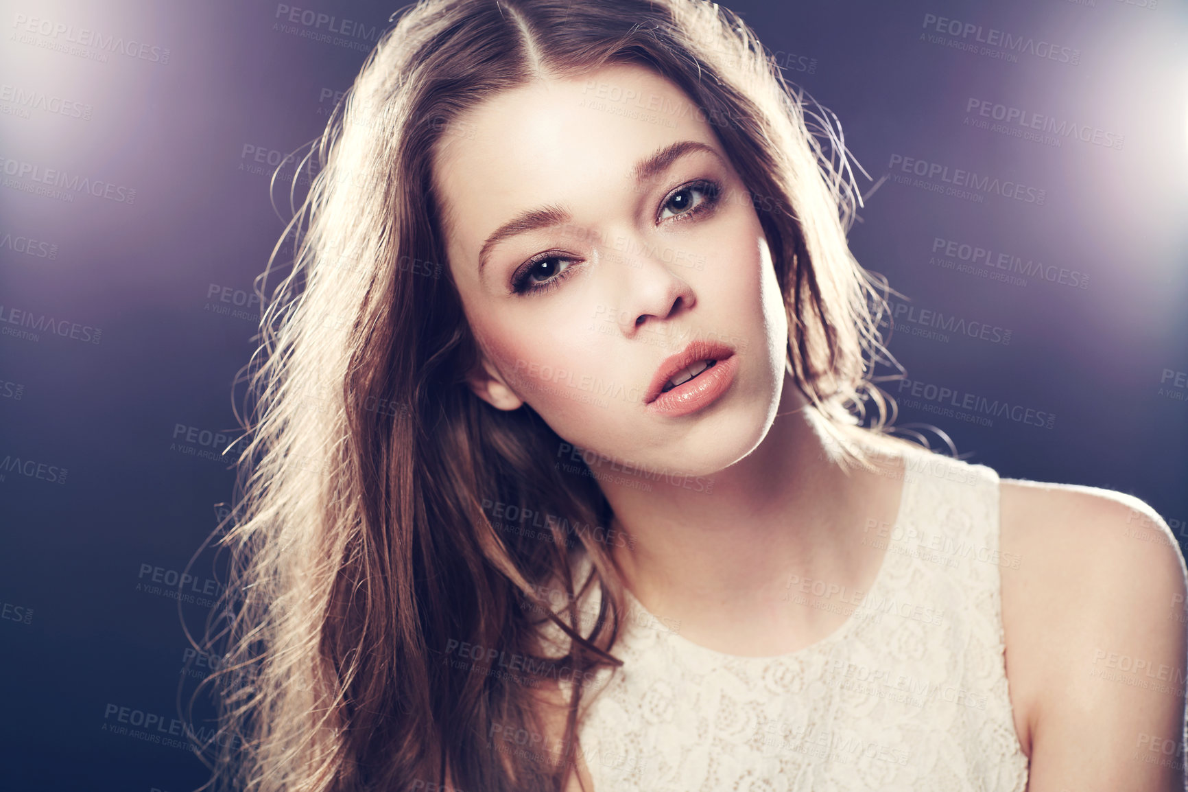 Buy stock photo A gorgeous young woman backlit with bright lights while isolated on black