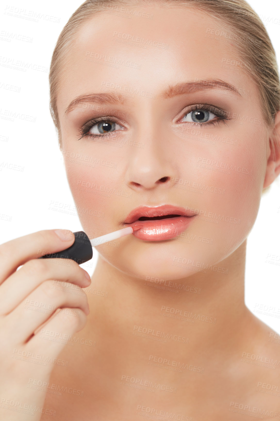 Buy stock photo A stunning young woman applying lipgloss to her luscious lips while isolated on white