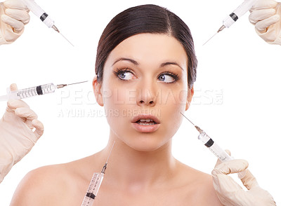 Buy stock photo A young woman looking scared while five injection needles point at her face