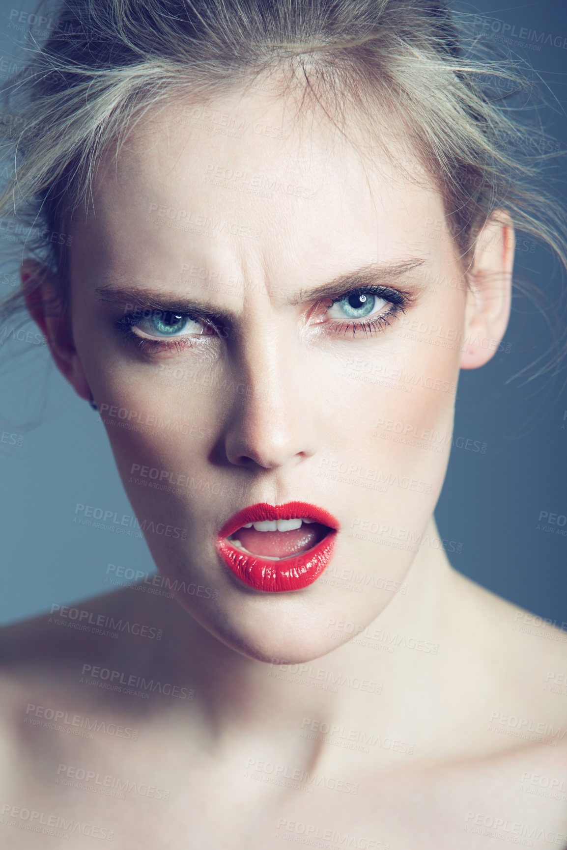 Buy stock photo Studio shot of a beautiful young woman looking angry against a gray background