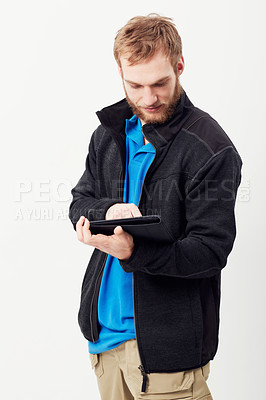 Buy stock photo Man, tablet and typing in studio, thinking and notes with click, scroll and reading by white background. Person, digital touchscreen and press for blog, email notification or social network on app