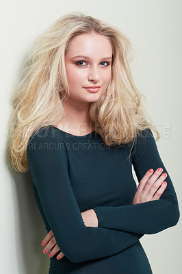 Buy stock photo A gorgeous young model with wild, blonde hair crossing her arms and looking at you confidently