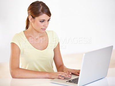 Buy stock photo Cropped shot of a beautiful young woman working on her laptop at home