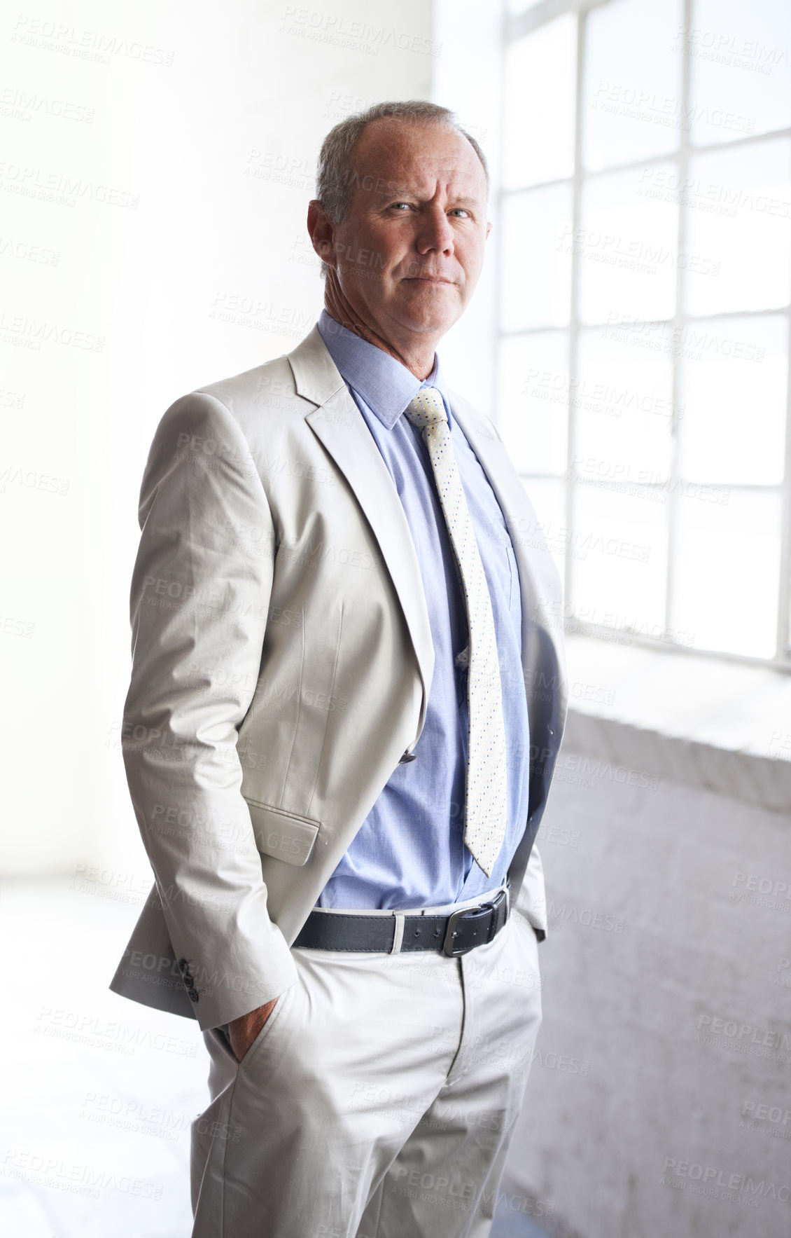 Buy stock photo Portrait of an experienced businessman standing in his office at the window