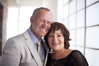 Buy stock photo A loving mature couple embracing one another in their new office space