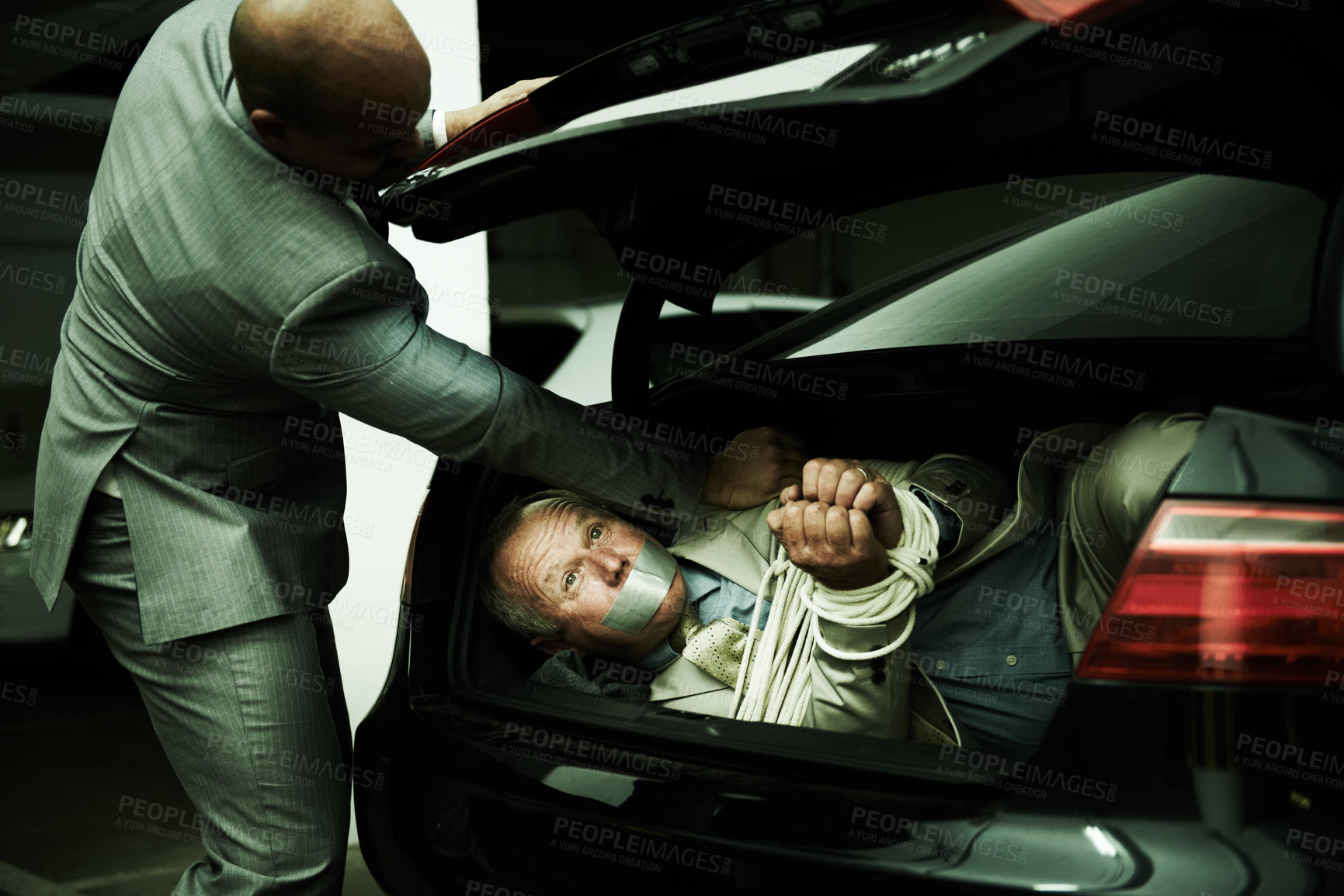 Buy stock photo Man in trunk of car, kidnap and mafia with violence, danger and fear in basement garage. Criminal, human trafficking and scared person tied with rope parking lot with gangster, ransom and terror.