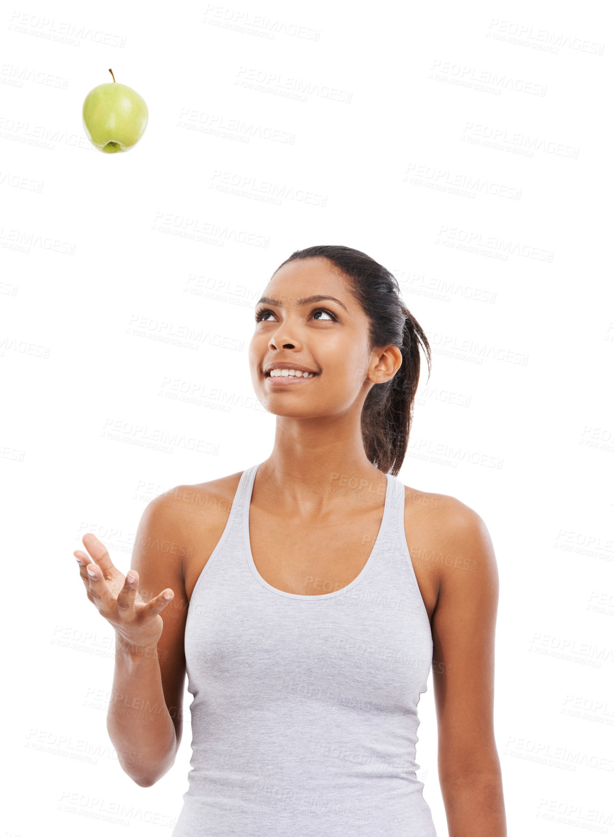 Buy stock photo A pretty young woman tossing an apple into the air while isolated on a white background