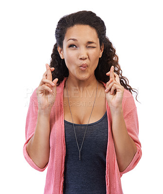 Buy stock photo Wink, hope and fingers crossed with a black woman in studio on a white background wishing for luck. Thinking, idea and wish with an attractive young female feeling lucky with a hand sign or gesture