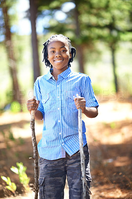 Buy stock photo Happy black child, portrait and hiking with sticks for walking, adventure or outdoor exploring in forest. Young African male person or kid smile for trekking, trip or holiday in woods or nature