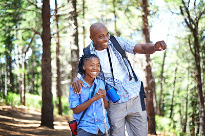 Buy stock photo Happy black family, forest and hiking for bonding, fresh air or exploring together in nature. Dad pointing and showing child or kid trees on adventure for holiday, weekend or outdoor trip in woods