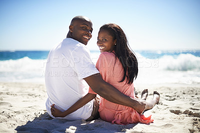 Buy stock photo Rear, portrait and smile with a black couple on the beach for travel, romance or adventure together. Summer, love or dating with a happy young man and woman sitting on the sand by the ocean or sea