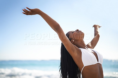 Buy stock photo An african-american woman with her arms outstretched and eyes closed at the beach