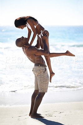 Buy stock photo Lifting, hug and couple at a beach with love, romance and bonding in nature together. Support, travel and black people embrace at sea with freedom, energy and excited for summer, vacation or trip