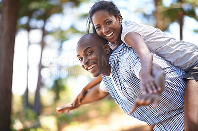 Buy stock photo Piggyback, portrait or black couple playing in park to relax or bond on holiday vacation together to travel. Romantic, happy or African woman with smile, care or man in woods on fun outdoor adventure