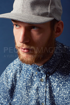 Buy stock photo A young man with a beard and unique sense of style looking away