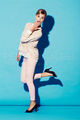 Buy stock photo Portrait, wow and gossip with a woman in studio on a blue background feeling surprised or shocked. Fashion, omg and hand on mouth with an attractive young female model looking amazed by surprise