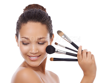 Buy stock photo Woman, beauty and makeup brushes on face for cosmetics, skincare or blush against a white studio background. Female person or model smile for facial treatment, foundation or textures on mockup space