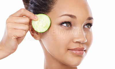 Buy stock photo Woman, face and cucumber by eyes in skincare, beauty or facial and spa treatment against a white studio background. Closeup of female person or model with natural organic vegetables for wellness