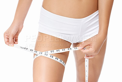 Buy stock photo Woman, legs and tape measure for diet, weight loss or slim body in health and wellness on a white studio background. Closeup of female person or model hands measuring thigh in fitness or healthcare