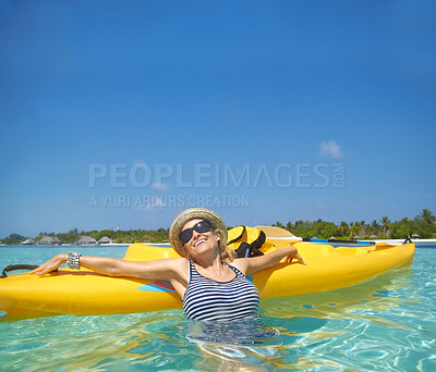 Buy stock photo A beautiful young woman relaxing in a tropical ocean with her boat
