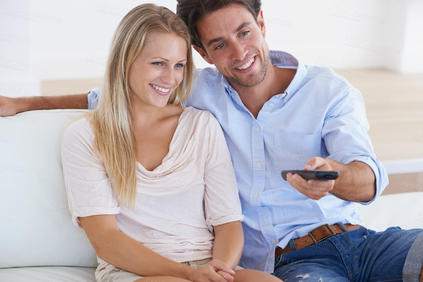 Buy stock photo Happy couple, relax and watching TV for entertainment, holiday or weekend together at home. Man and woman smile with remote for streaming movie, series or show in comfort on living room sofa at house