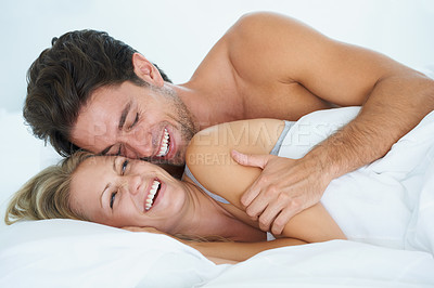 Buy stock photo A husband embracing his wife affectionately while lying in bed together