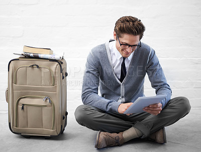 Buy stock photo Business man, reading or luggage with tablet, floor and smile with app, flight or travel by wall background. Entrepreneur, person or employee with digital touchscreen, bag and happy for immigration