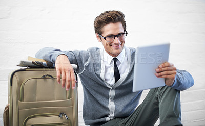Buy stock photo Business man, reading or suitcase with tablet, floor and smile with app, flight or travel by wall background. Entrepreneur, person or touchscreen on social media, bag or check booking for immigration