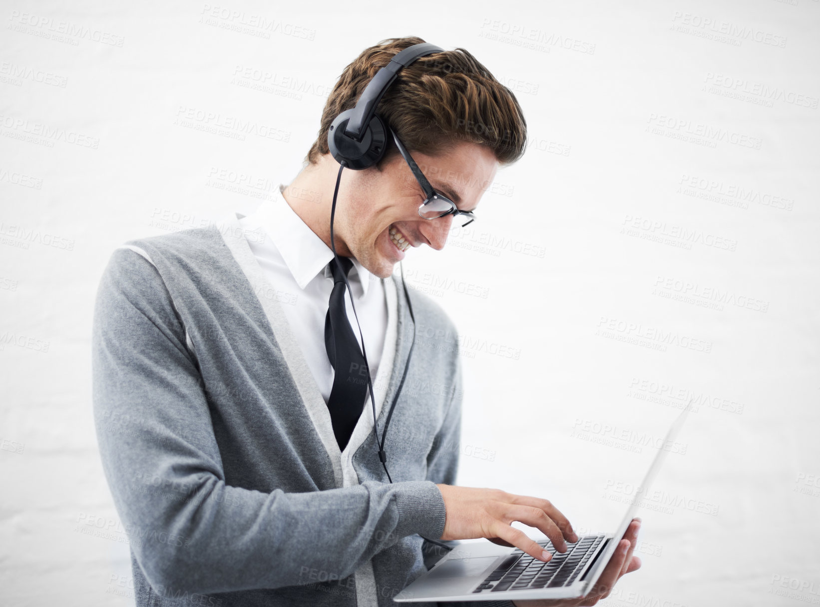 Buy stock photo Happy man, laptop and headphones listening to music, audio or streaming on a gray studio background. Male person, nerd or geek smile with computer and headset for sound or podcast on mockup space