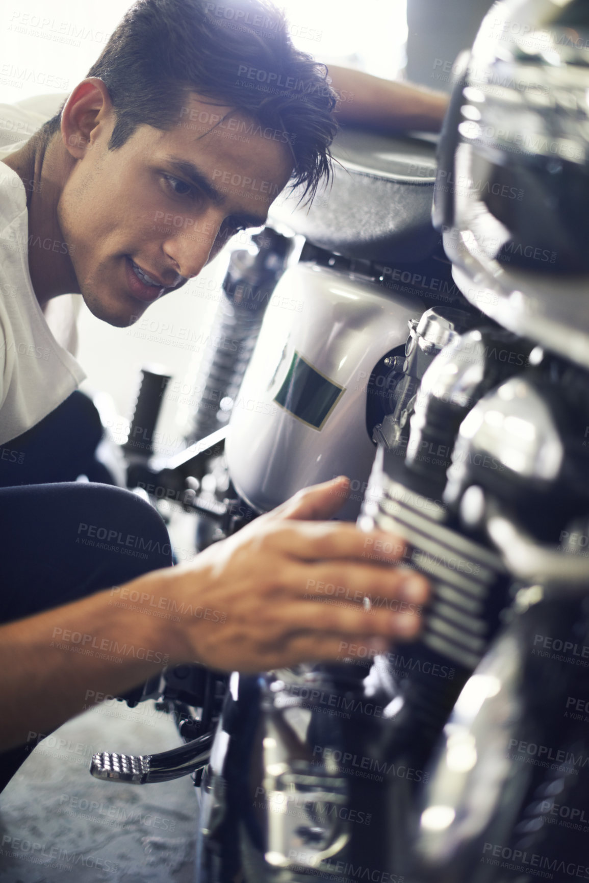 Buy stock photo A handsome young man admiring his motorcycle