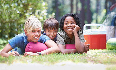 Buy stock photo Camping, children and relaxing in portrait on vacation, bonding and happy for outdoor adventure. Kids, face and smiling together on holiday, friendship and childhood in nature, resting and grass
