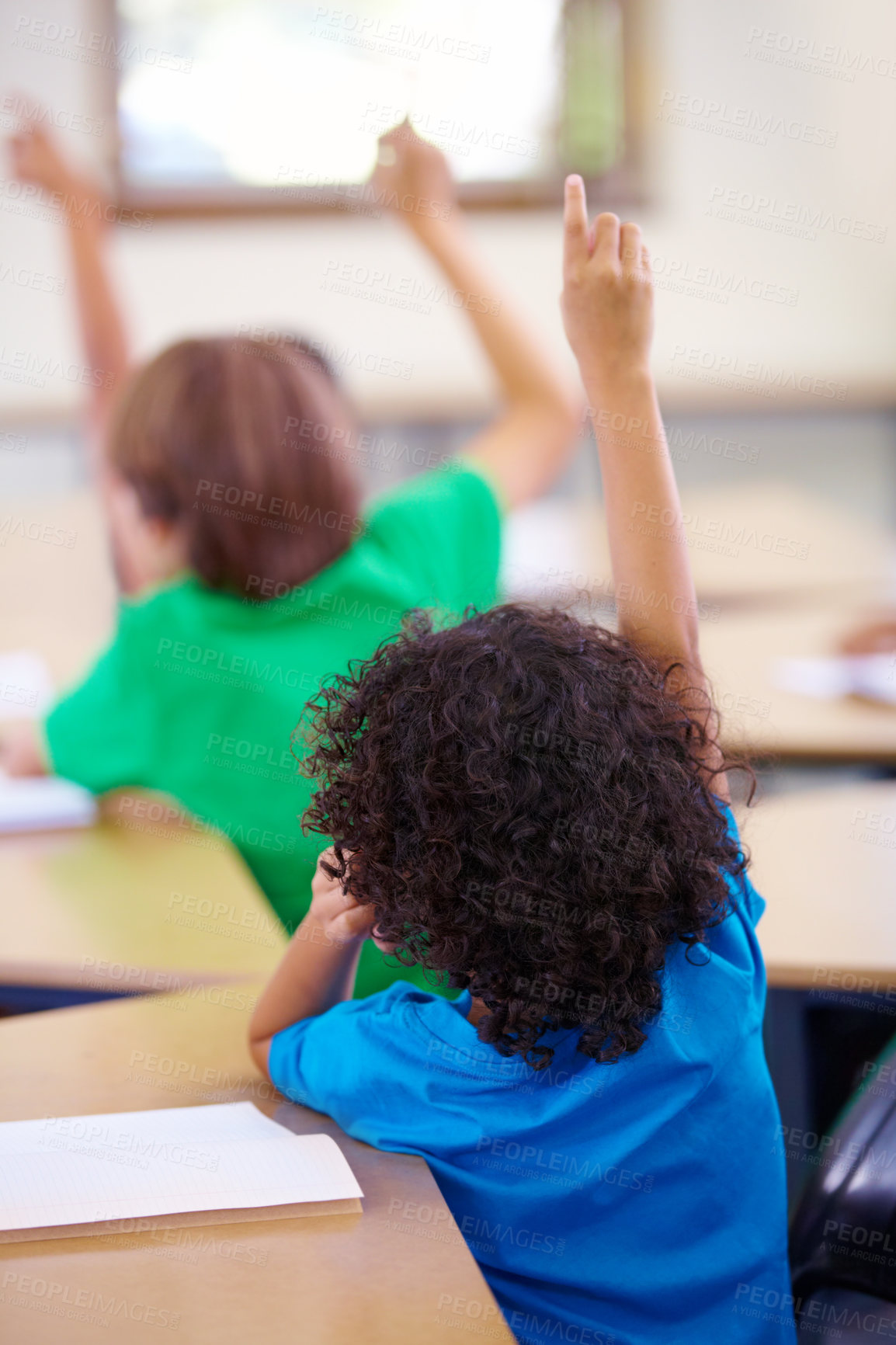 Buy stock photo Rearview shot of schoolchildren holding their hands up to answer a question in class