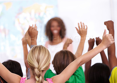 Buy stock photo Happy woman, teacher and students with question in classroom, presentation or lesson at school. Female person, educator or lecturer with group of learners with hands raised for interaction in class