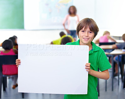 Buy stock photo Portrait of a young schoolboy holding up your copyspace in class