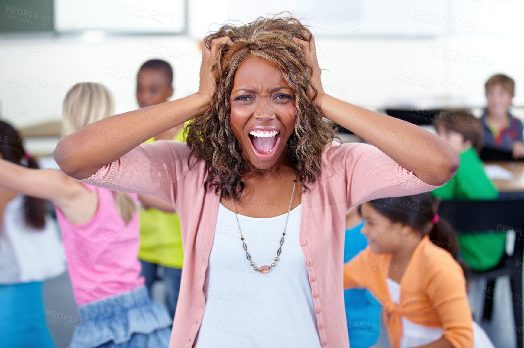 Buy stock photo Shot of a young teacher in a classroom full of children