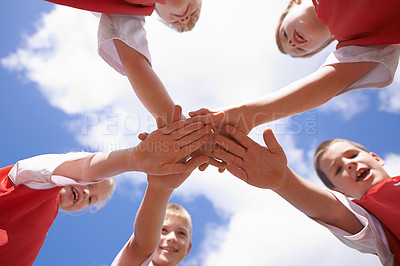 Buy stock photo Hands, huddle and group of children on soccer team, team building and collaboration or support in circle. People, solidarity and team or partnership and trust in community, unity and sky background