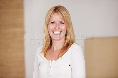 Buy stock photo A beautiful mature woman laughing while standing in her living room